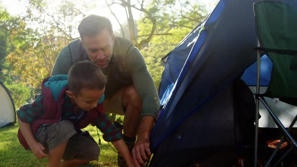 Father and son setting up a tent