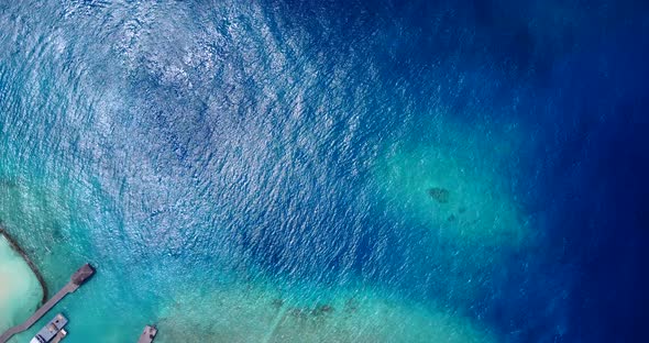 Natural fly over travel shot of a sunshine white sandy paradise beach and blue water background in c