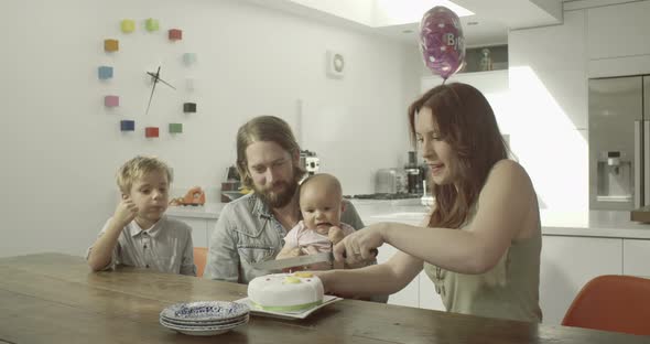 Family celebrating birthday with cake