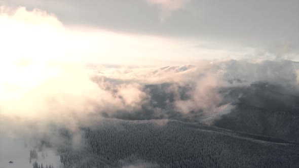 Aerial Flying Above Mountain Valley and Winter Forest at Sunrise