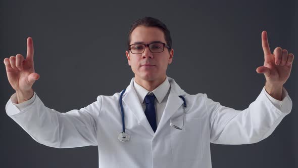 Studio portrait of young professional medical doctor standing over grey background