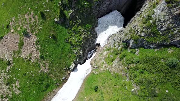 Top View of Steep Mountain Cliffs and an Ice Cave