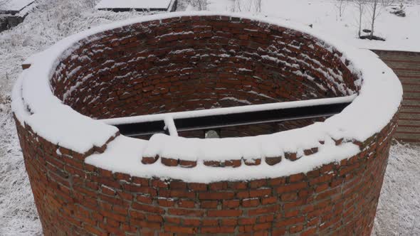 A Brick Abandoned Water Tower in the Middle of a Forest and Abandoned Buildings in a Winter