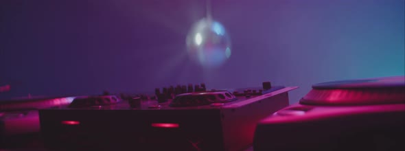 DJ equipment lit by purple light