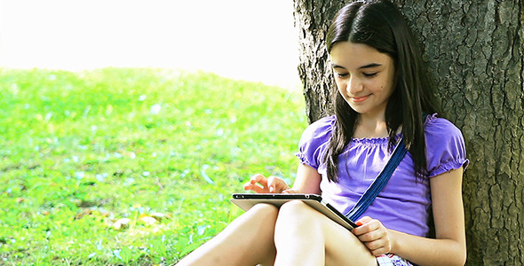 Teenage Girl Using Digital Tablet in Park 1