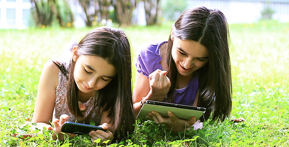 Girls Playing on Digital Tablet and Smartphone