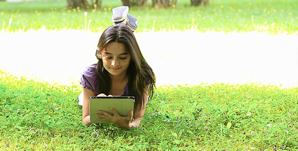 Teenage Girl Using Digital Tablet on Grass 2 