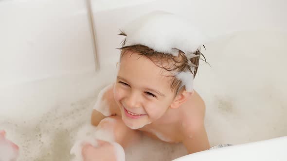 Closeup of Young Mother Playing with Her Little Son Taking Bath and Washing Hair with Shampoo
