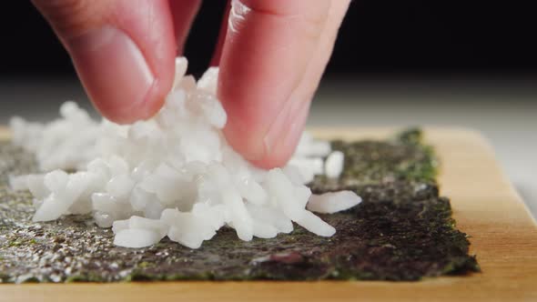 Sushi Chef's Hand Puts A White Rice On A Nori