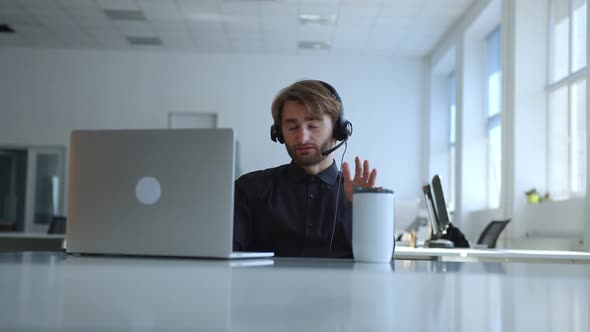 Man in Headphones Explains Work to the Customer