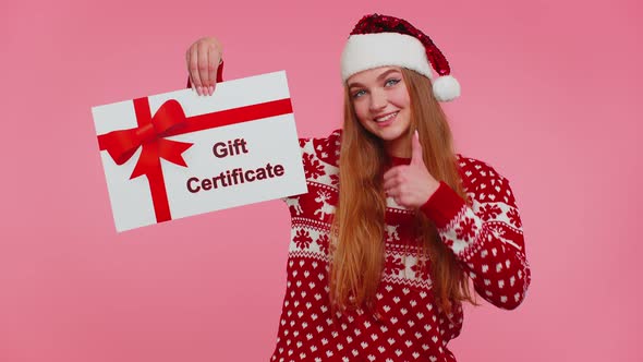 Adult Girl Wears Red New Year Sweater and Hat Presenting Card Gift Certificate Coupon Winner Voucher