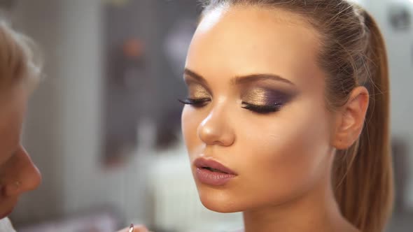 Closeup View of the Professional Makeup Artist Applying Lipstick Using Special Painting Brush to a