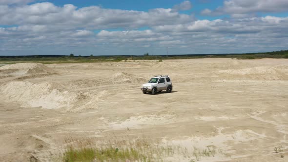 Aerial View of a Car Driving on Sand