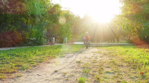 Boy Kicks Off and Rides a Bike