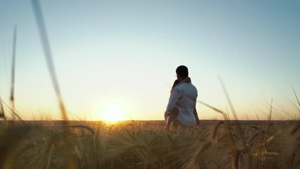 Father Holding Daughter in Arms in Field