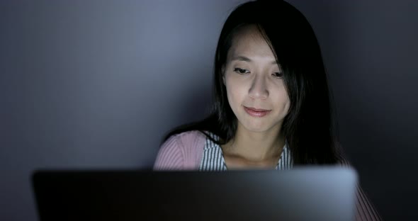 Woman working on laptop computer at night 