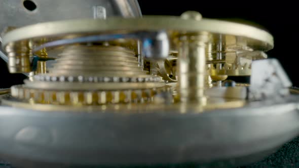 Inside View of a Moving Clockwork of Golden Mechanical Clock on Black Isolated Studio Background