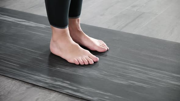Closeup on Legs of Barefoot Woman on Mat Warming Up Preparing for Exercises