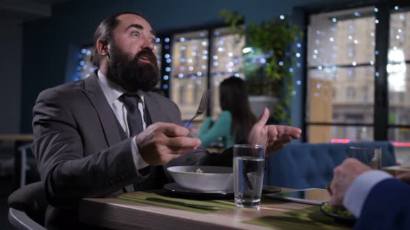 Portrait of Eating, Talking Man at Business Lunch