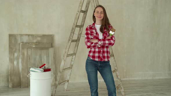 Woman Paints Walls at Home Holds Paint Brush