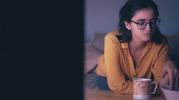 Cinematic Happy Girl Relaxes Near Tv at Night and Eats Potato Chips Home Evening at the TV