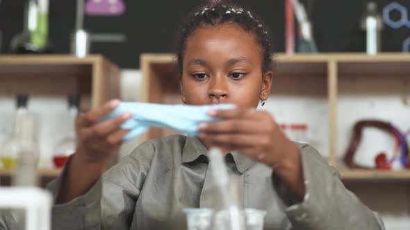 Laboratory Experience in a Chemistry Lesson, African Girl Playing with a Light Blue Slime, Children