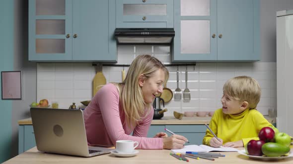 Young Woman and a Boy Draw with Felttip Pens in an Album