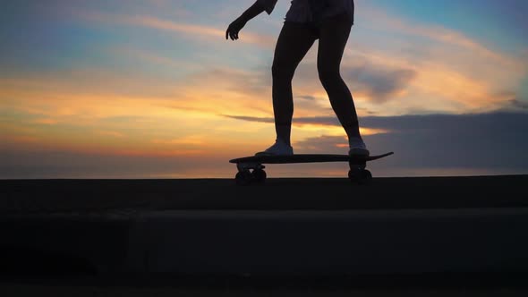 Silhouette of a Skateboarder Against the Sunset Sky in Slow Motion Steadicam Shot