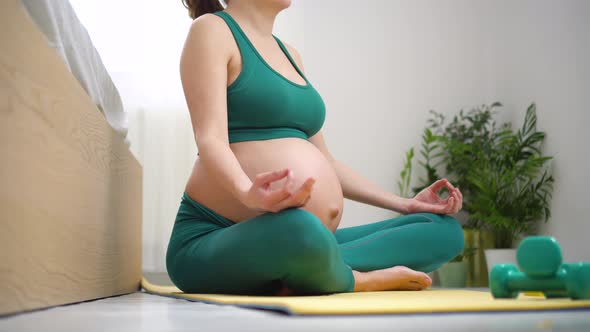 A Pregnant Woman is Exercising with Breath