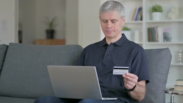 Middle Aged Businessman Making Successful Online Payment on Laptop