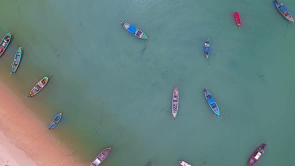 Hyperlapse Aerial view top down on longtail fishing boats at the sea, Moving up shot and rotate 