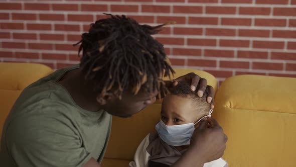 Black Dad Putting on Protective Mask on Son's Face Before Walk Slow Motion