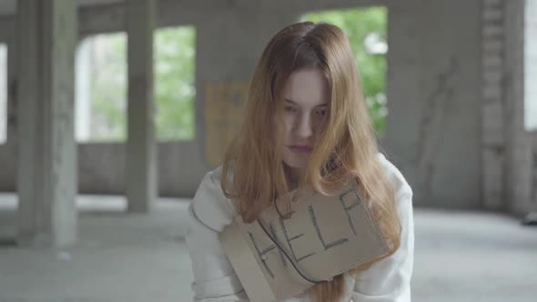 Portrait of Caucasian Young Sad Girl Sitting in an Abandoned Building Having Drug Breaking