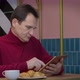 Handsome Middleaged Man Messaging and Chatting Typing on Tablet Screen in Cafe - VideoHive Item for Sale