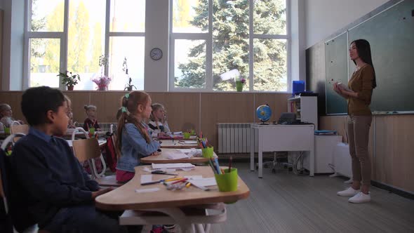 Woman Teacher Communicating with Pupils in Class