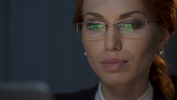 Businesswoman Taking Off Her Glasses and Looking Carefully at Laptop Screen