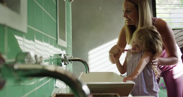 Mother and daughter brushing their teeth together