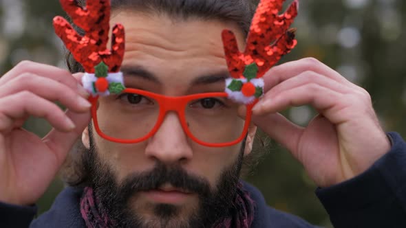 funny carefree happy man wearing christmas glasses smiling-outdoor