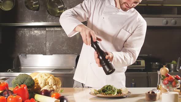 Male Chef Accompanying Salad with Pepper Salt