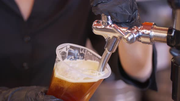 Bartender Pouring Beer Into Glass with Bubbles Close Up