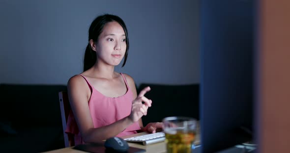 Woman using desktop computer at night