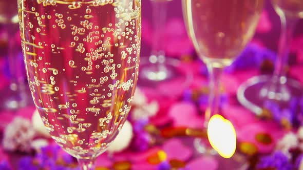 Falling confetti on glasses with sparkling wine, round candy with coconut flakes 