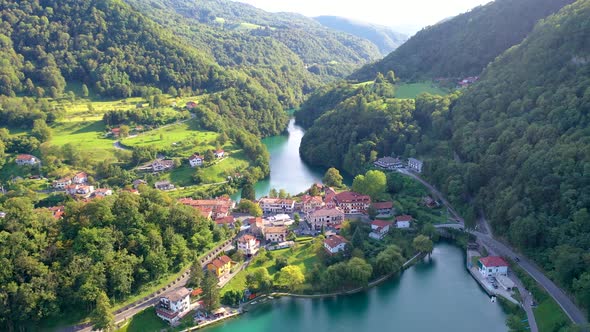 Aerial view of a peaceful town surrounded by green mountains and a beautiful river