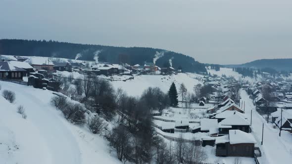 Aerial View of Smoke Coming From Stoves in Wooden Houses in the Village in Winter