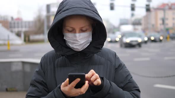 Young Woman Using Smart Phone In The City Wearing Face Mask Because Of Air Pollution, Flu Virus