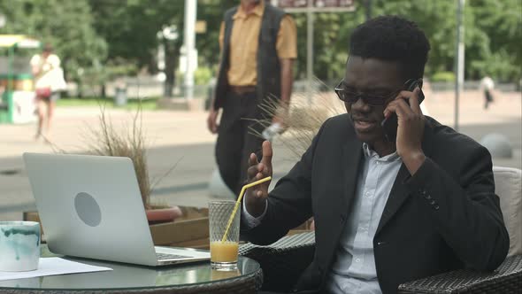 Afro-American Businessman Negotiating By Phone, Defending His Interests and Opinion