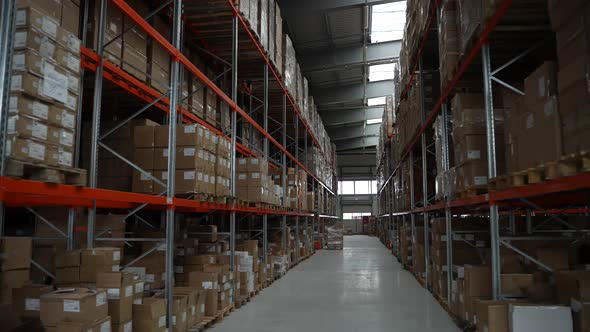 Rows of Racks with Cardboard Boxes in Warehouse