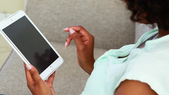 Woman using digital tablet in living room