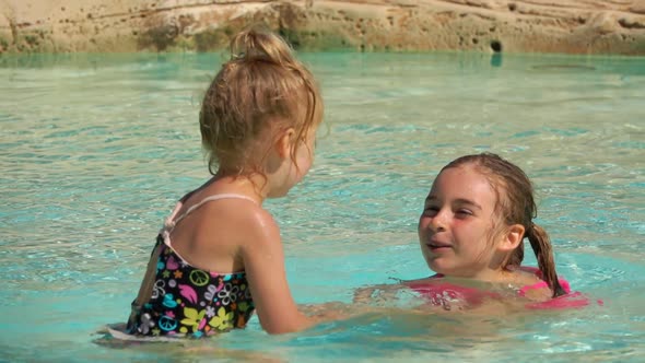 Two Sibling Girls are Playing Together in the Swimming Pool