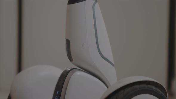 White Modern Gyro Scooter Gadget Stands in the Room and Keeps Balance Itself